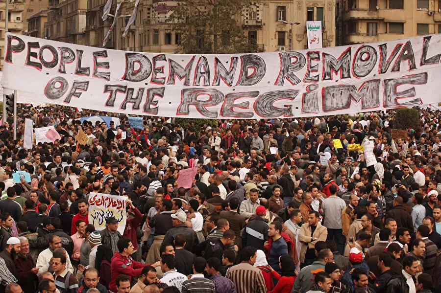 Arap Baharı gösterileri sırasında "Halk rejimin yıkılmasını istiyor" pankartı açan Tunuslular.