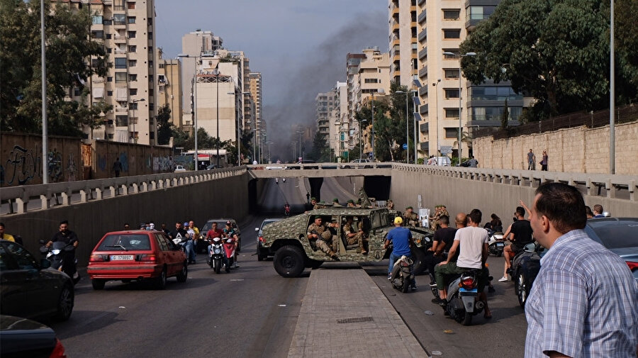 Göstericilerle karşı karşıya kalan bir askeri araç geri manevra yaparken görülüyor.