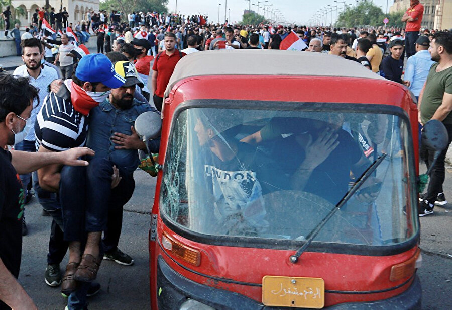 Gösteriler sırasında yaralan Iraklı bir protestocu, sivil araçlarla hastaneye taşınıyor.