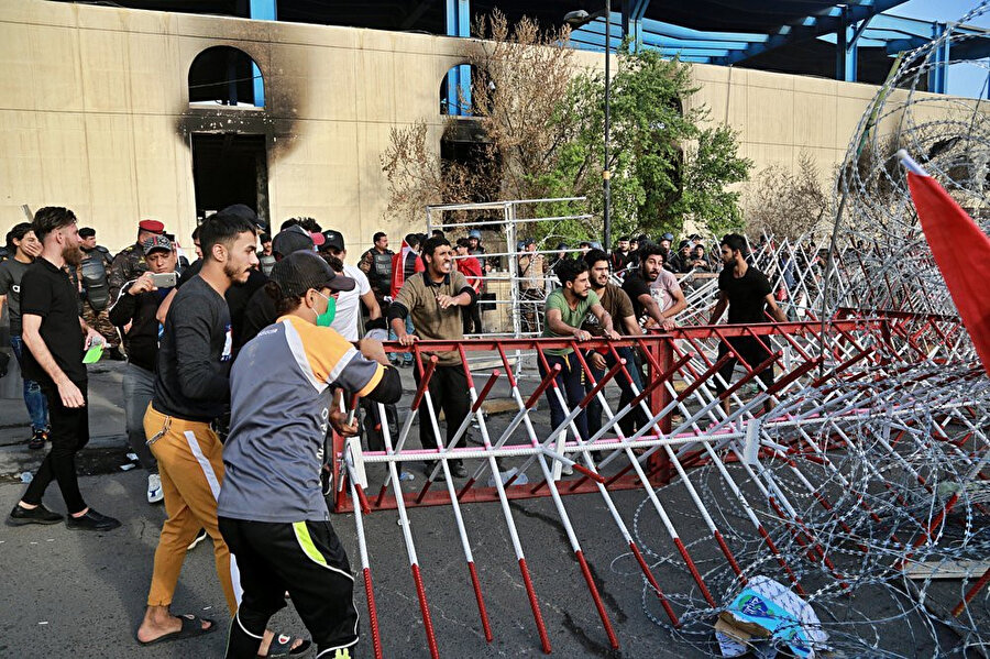 Hükümet binaları ve yabancı misyonlarının bulunduğu Yeşil Bölge’ye ulaşmaya çalışan göstericilerin barikatları kaldırmaya çalıştıkları görülüyor.