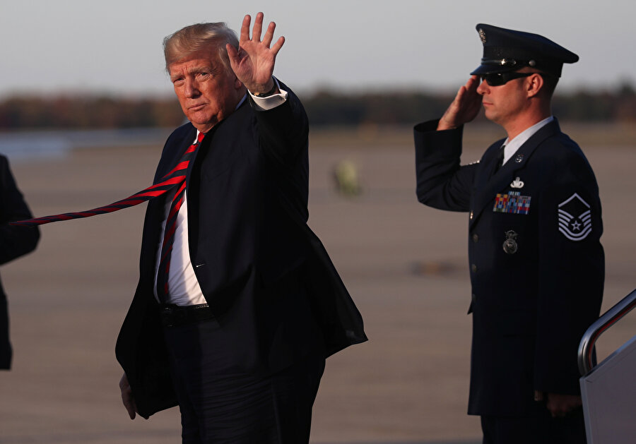 ABD Başkanı Donald Trump gazetecileri selamlarken görünüyor.