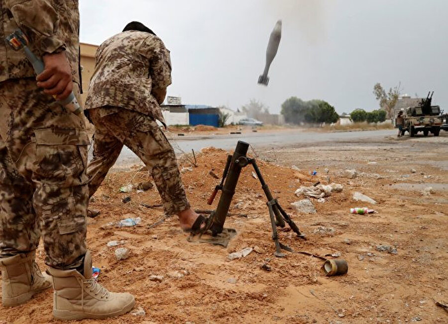 UMH'ye bağlı birliklerden bir savaşçı Hafter güçleriyle çatışmalar sırasında bir havan mermisi ateşlerken görülüyor.