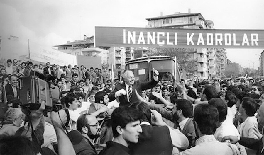 Necmeddin Erbakan "İnançlı Kadrolar" pankartı önünde.