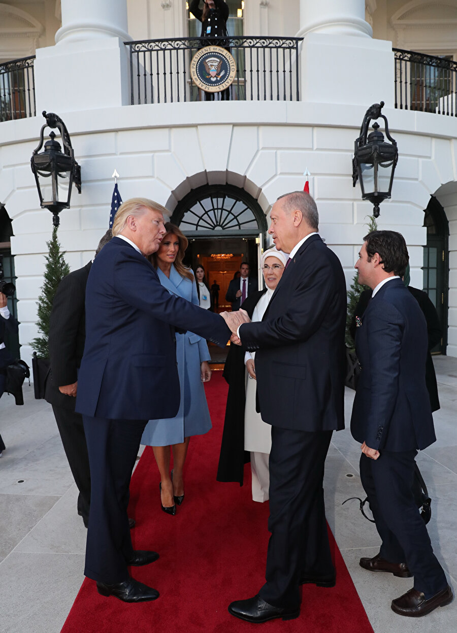 Beyaz Saray önünde liderlerin samimi tokalaşması. Erdoğan Trump'ın elini sıkarken diğer eliyle de tutarak daha sıcak bir görüntü sergiliyor.