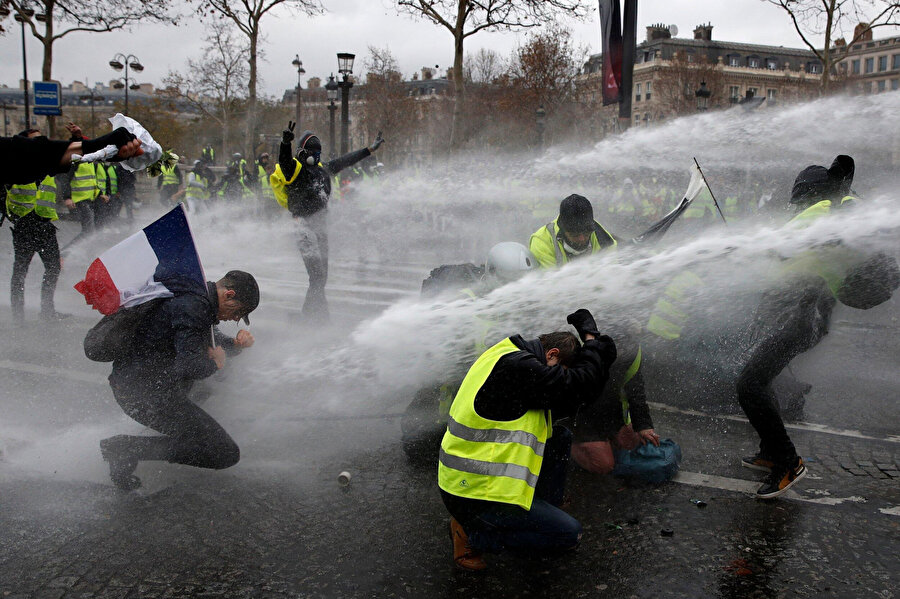 Polis sarı yeleklilere biber gazı uyguluyor