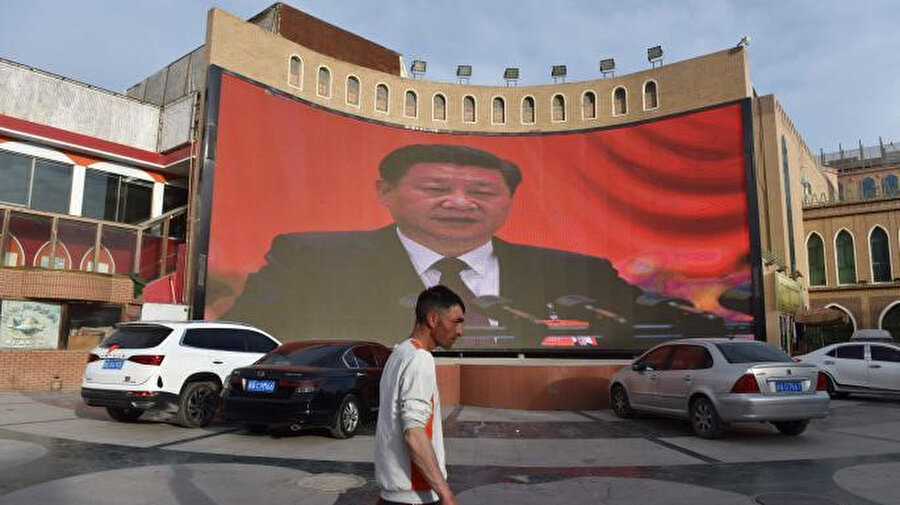 Çin Devlet Başkanı Şi Cinping'in yoğun olarak Uygun Türklerinin yaşadığı Kaşgar'da dev ekrandan halka hitap ettiği görülüyor.