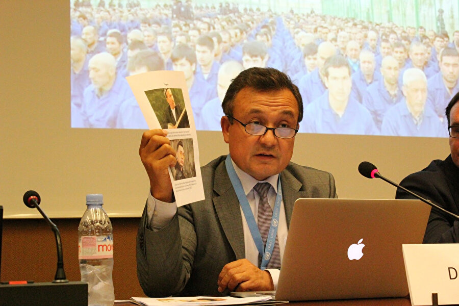 Dünya Uygur Kongresi'nde konuşan Dolkun İsa, Çin kamplarında tutulan Uygur sanatçıyı katılımcılara gösteriyor.