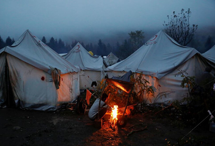 Odun ateşinde ısınmaya çalışan mülteciler.