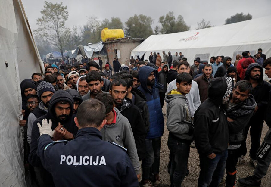 Mültecilerle karşı karşıya gelen bir polis memuru.