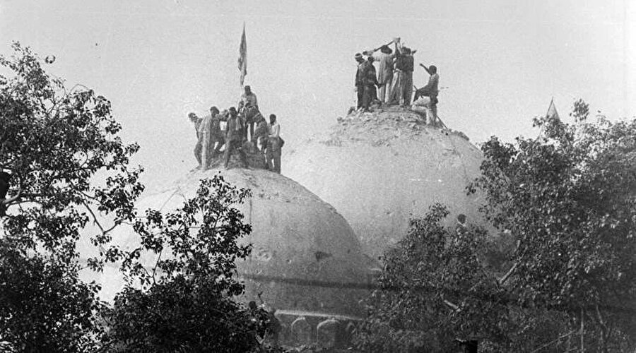 Babri Camisi'ni kubbelerini yıkmaya çalışan Hindular.