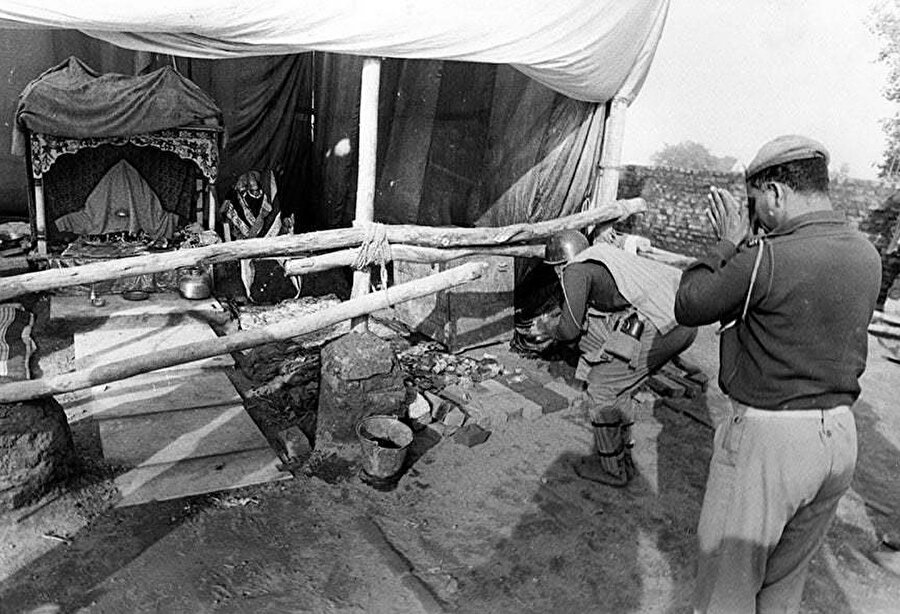 Babri Camisi'nin 6 Aralık 1992'de yıkılmasından bir gün sonra apar topar inşa edilen Rama tapınağında dua eden bir Hint asker.