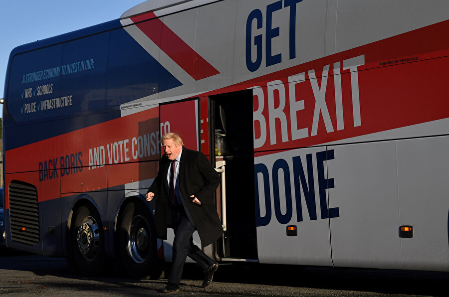 Başbakan Boris Johnson seçim otobüsünden inerken görünüyor.