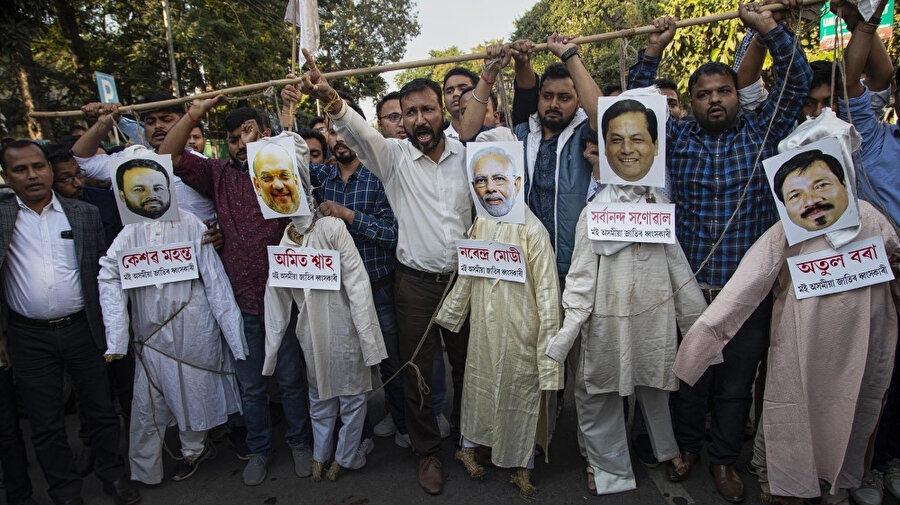 Başbakan Modi ve İçişleri Bakanı Amit Şah'ın da aralarında bulunduğu siyasilerin kuklalarını asan göstericiler.