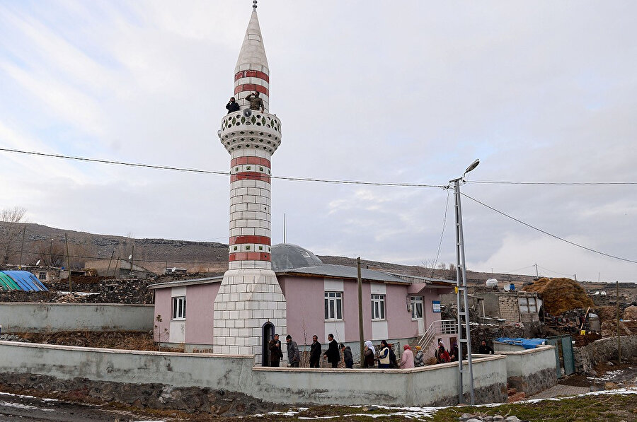 Köylüler cami minaresine çıkabilmek için sıraya giriyor. 