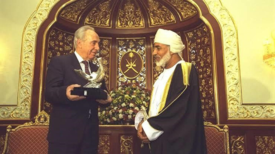 1996'da dönemin İsrail Başbakanı Şimon Perez, İsrail ile iyi ilişkiler kuran Umman Sultanı Kâbûs bin Saîd'e barış güvercini heykeli sunarken.