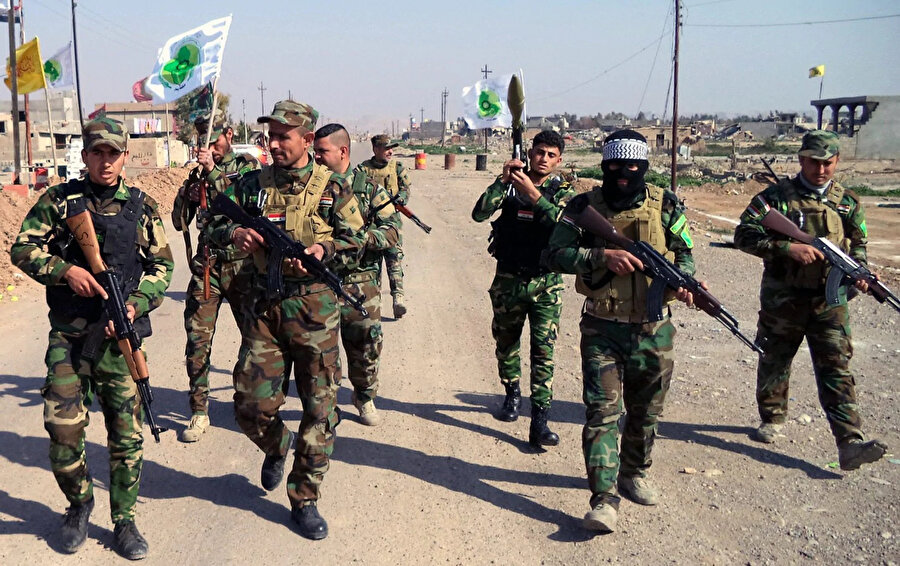 Haşdi Şabi'ye bağlı Bedir Tugayları militanları Irak sokaklarında devriye gezerken görülüyor.