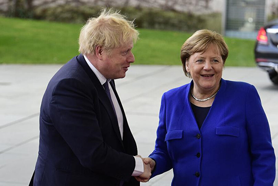 Boris Johnson ve Merkel el sıkışırken