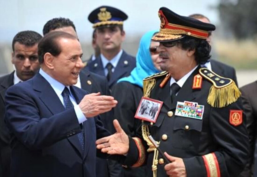 Yakasında Ömer Muhtar’ın İtalyanlar tarafından zincire vurulmuş fotoğrafını taşıyan Kaddafi’yi gören Berlusconi şok oldu.