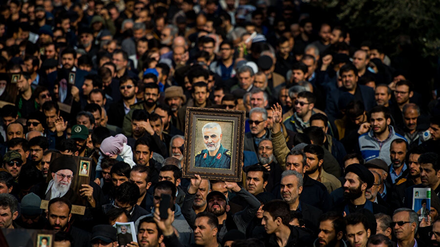 ABD tarafından öldürülen Kudüs Gücü Komutanı Kasım Süleymani ve dini lider Ali Hamaney'in fotoğraflarını taşıyan İranlılar.