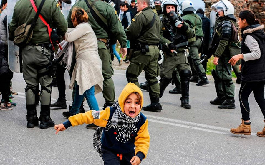 Midilli'de gerçekleştirilen protestolara polisin müdahalesi sırasında ortaya çıkan gerginlikten kaçmaya çalışan bir göçmen çocuğu. 