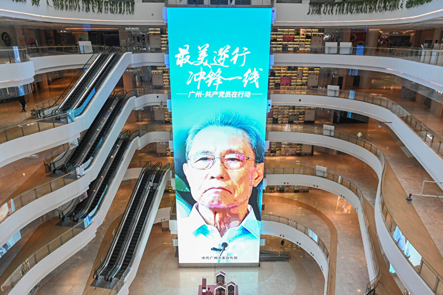 Boş bir alışveriş merkezinde, 2003 yılındaki SARS koronavirüsünü keşfeden Zhong Nanshan'ın afişi görünüyor.