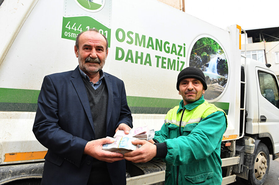 Temizlik işçisi Ahmet Gökçe, emekli işçi Nurettin Kılıççı'ya verirken