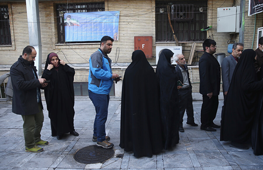 İranlı seçmenler oy kullanmak için sırada bekliyor
