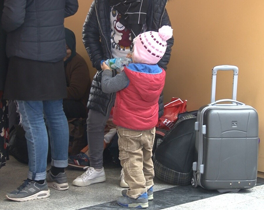 Avrupa yolculuğuna hazırlanan küçük göçmen çocuk su içerken görünüyor.