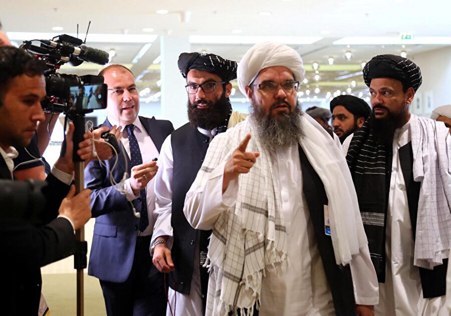Taliban Heyeti, anlaşma öncesi basın mensuplarına açıklama yaparken görülüyor.