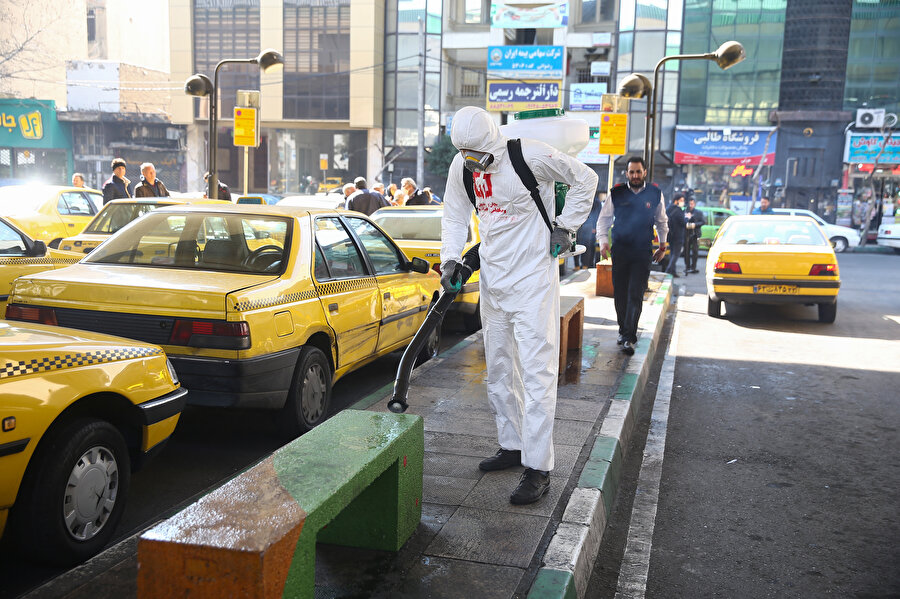 Tahran'da bir taksi durağı dezenfekte ediliyor