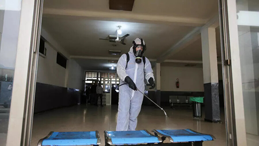 Cezayir'de otobüs duraklarında dezenfeksiyon çalışmaları yürüten bir görevli.