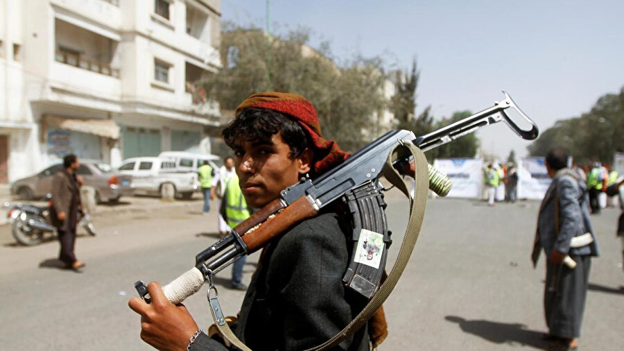 Yemen'in San’a kentindeki bir toplantı sırasında elinde silahla görüntülenen bir Husi destekçisi. (2 Nisan 2020)