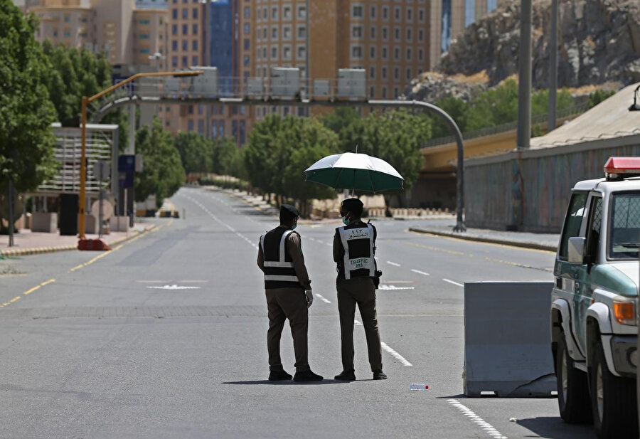 Sokağa çıkma yasağının uygulandığı Mekke'de polis caddelerde kontrol noktaları oluşturmuş durumda.