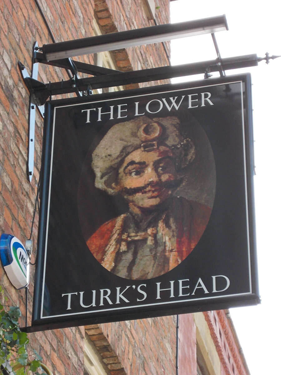 “Turk’s Head” tabelası, Britanya’da çeşitli restoran ve barlarda olduğu gibi okuma yazma bilmeyen halk için dükkânda ne satıldığına dair bilgi vermek için de kullanılmış.