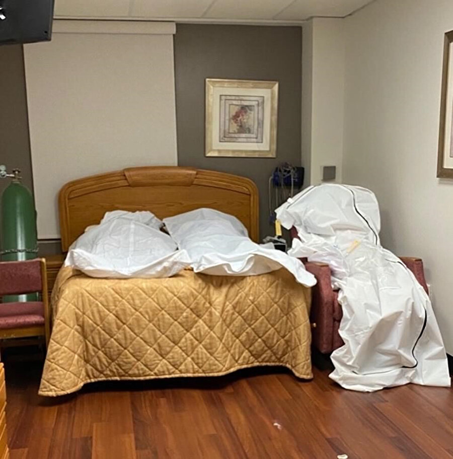 Fotoğrafta ceset torbasındaki iki bedenin yatağa, üçüncüsünün ise sandalyeye konulduğu görülüyor
