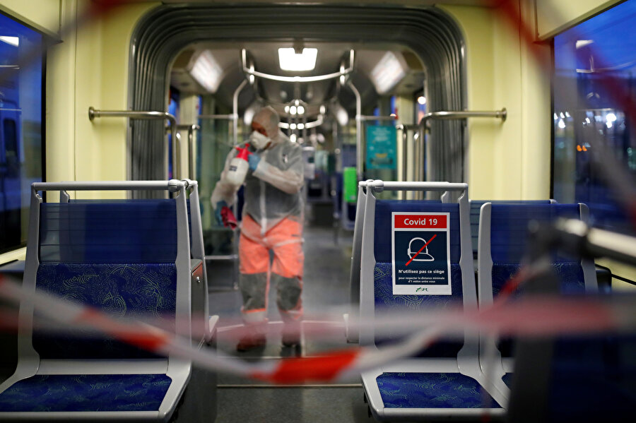 Fransa'da bir kişi metroyu dezenfekte ederken görünüyor.
