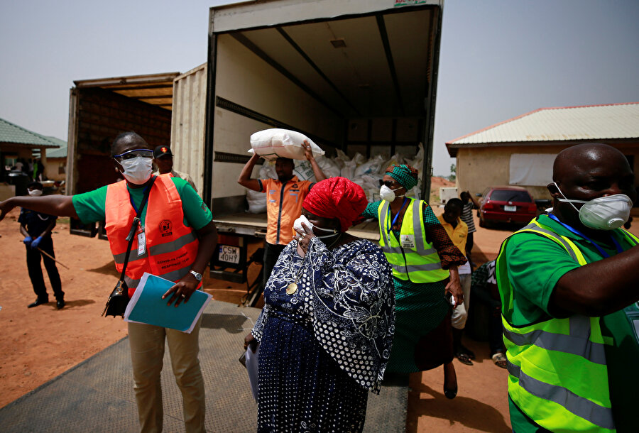 Evlerinden edilen Nijeryalılar yemek yardımı alıyor