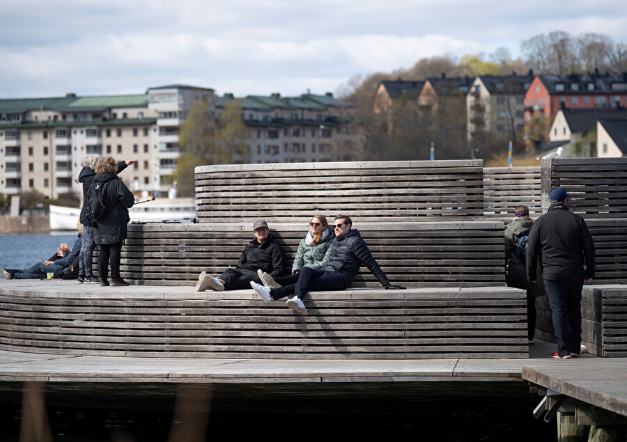 Salgın döneminde İsveçli vatandaşlar açık alanda otururken görünüyor. 