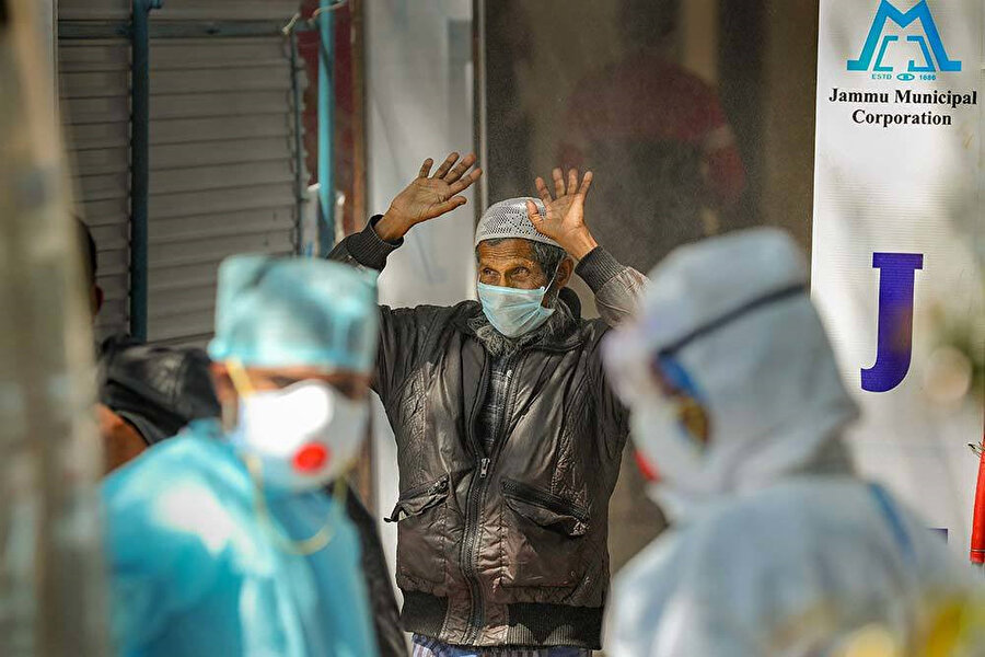 Hindistan'a bağlı Cammu'da bir Müslüman, hastanenin bahçesine kurulan tüm vücut sterilizasyonu için hazırlanan geçite doğru yürürken görülüyor.