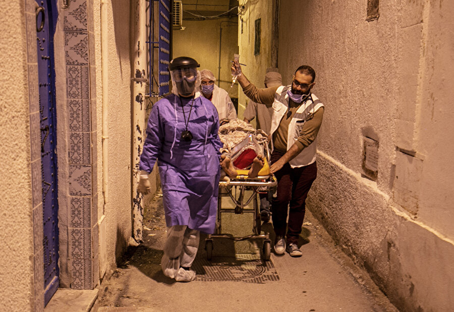 Tunus'un dar sokaklarından ambulansa taşınan bir hasta.