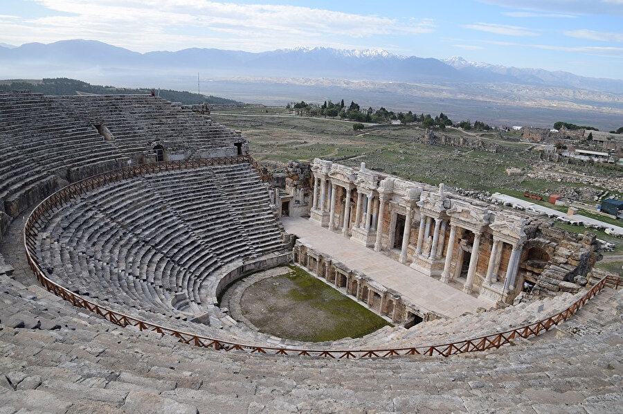 Grek Tiyatrosu tipinde yamaca yaslanmış 300 ayak (91 m) tüm cephesiyle birlikte korunabilen büyük bir yapıdır.