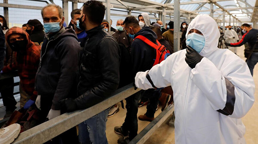 İsrail işgali altındaki Batı Şeria'da, İsrail'e geçmek üzere kontrol noktalarında bekletilen Filistinli işçileri izleyen bir sağlık çalışanı.