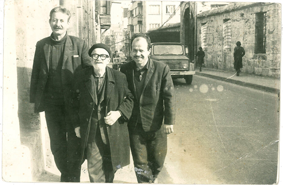 İşte fotoğrafta ortadaki küçük vücutlu, koluna girildiği hâlde yürüyen, fakat nur yüzlü mütebessim çehreli zat Üsküp’ten İstanbul’a hicret eden Rifâî meşâyihinden Haznedar Mustafa Efendi’dir. Sağındaki hazretin mahdumu Râik Efendi’dir. 