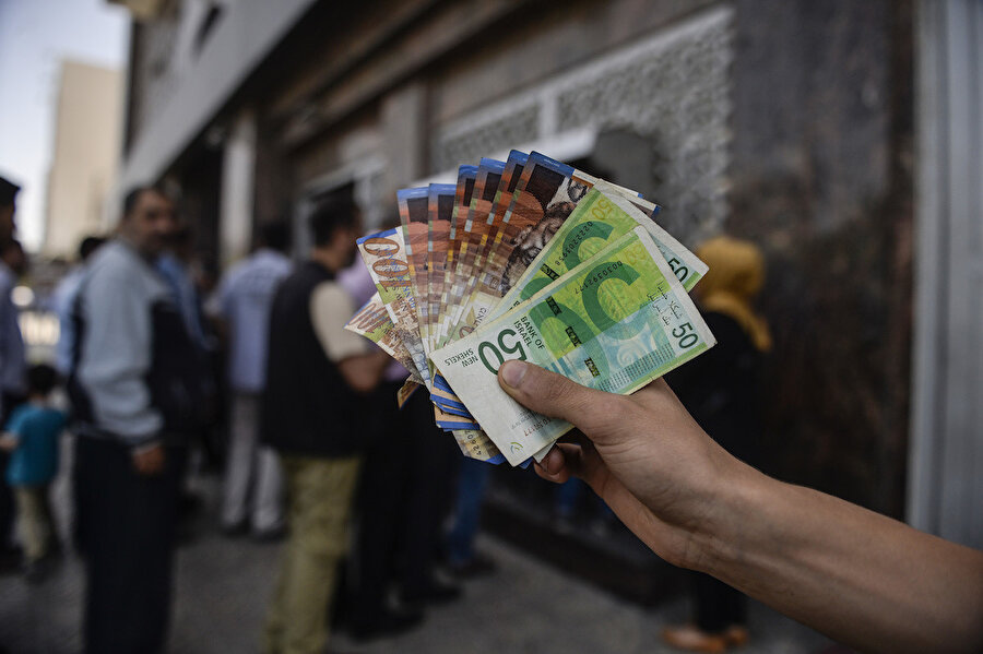 Para çekmek için bankamatikte sıra bekleyen Filistinliler.