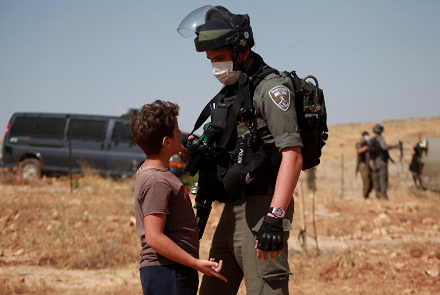 İsrail güçleriyle karşı karşıya kalan Filistinli bir çocuk.
