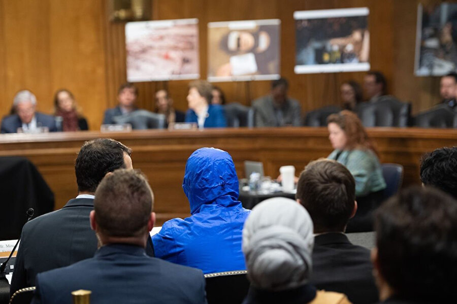 2014'te Esed rejiminin rejim muhaliflerini tuttuğu hapishanelerde işkenceyle öldürülen tutukluların fotoğraflarını dünya basınına sızdıran "askeri polis" Sezar (mavi kapüşonlu), ABD Senatosu Dış İlişkiler Komitesinde bring verirken görülüyor.