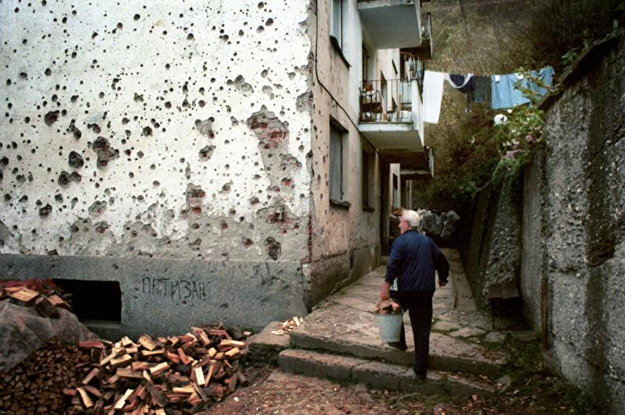 Srebrenitsa'da savaşın silinmeyen izlerinin yanından her gün geçmek zorunda olan bir apartman sakini.