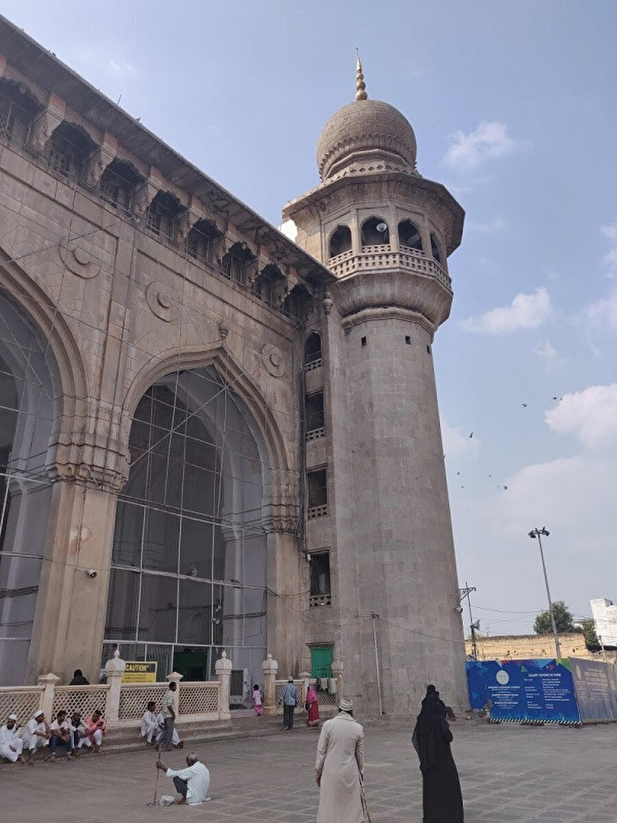 Mekke Mescidi'nin sekizgen balkonlu köşe minarelerin yüksekliği düşüktür ve caminin parapet (çatı) seviyesinin üzerine çıkmamaktadır.