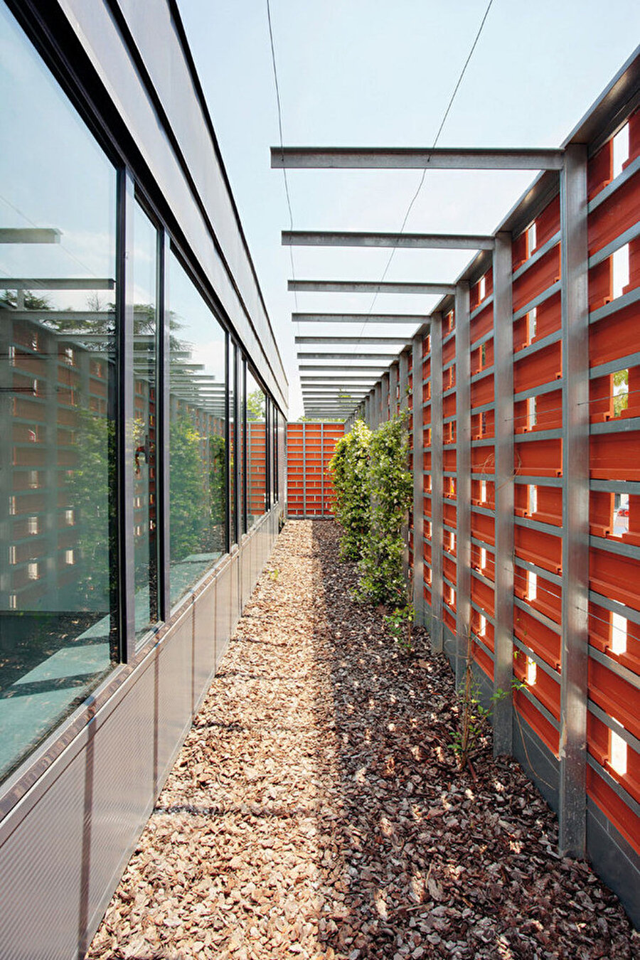 Yapıyı çevreleyen çitleri oluşturmak için, birbirine kenetlenmiş bir tarzda kullanılan turuncu tuğlalar.