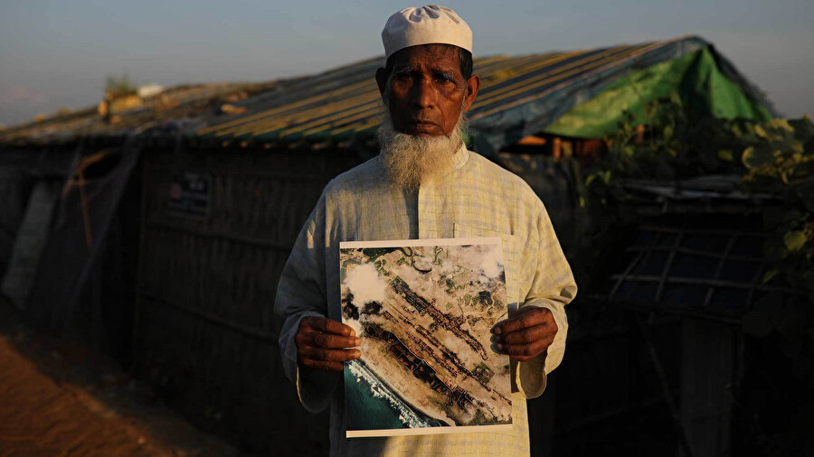  Myanmar güvenlik güçleri tarafından yakılan köyünün fotoğrafını gösteren Arakanlı bir Müslüman.